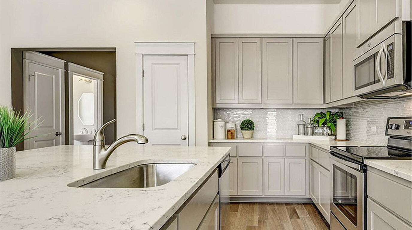 Modern kitchen with quartz island and light cabinetry in a new Austin-area home